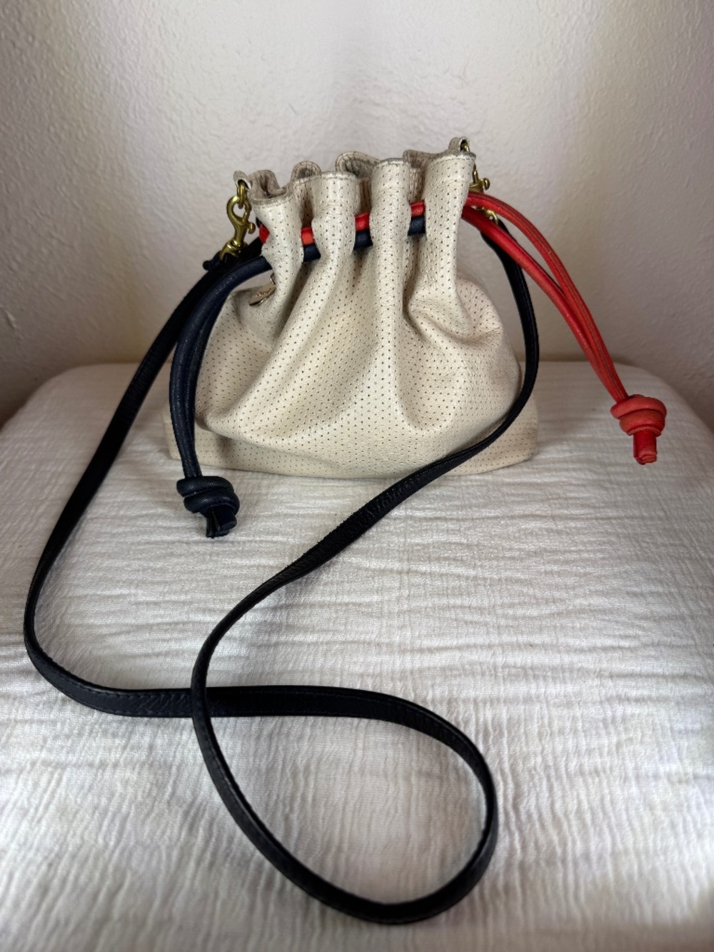 Claire V. Petit Henri Drawstring Bag Cream Perforated Leather Red Blue Accents